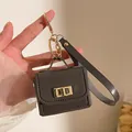 Mini-Geldbörse Schlüsselanhänger aus Kunstleder mit goldenen Details in der Hand - Dunkelgrau