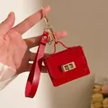 Mini borsa portachiavi in pelle PU rossa con chiusura a rotazione dorata tenuta in mano - Rosso
