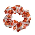 Close-up of a white satin scrunchie with a vibrant orange basketball print pattern - White Basketball