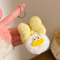 Close-up of cute plush keychain with big yellow bow and funny face held in hand - Yellow Bow with White Plush Ball