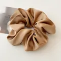 Close-up of champagne brown satin hair scrunchie showing glossy texture and elegant folds - Light Coffee