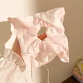 Close-up of pink plaid scrunchie with white lace edges and a delicate ribbon bow - Pink