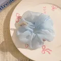 Light blue polka dot organza scrunchie with cute bear label on a ceramic tray - Blue Organza with Cartoon Bear Tag
