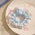Blue and white striped scrunchie with polka dots and lace trim on a white plate - Lace Polka Dot Blue