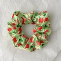 Macro shot of light green satin Christmas scrunchie with festive socks and candy patterns - Green Christmas Sock Style (Christmas Style 7)