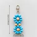 Sky blue flower keychain with wood bead and metal clasp, measuring 10cm by 3.5cm - Blue