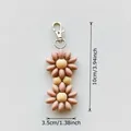 Pink beaded flower keychain with silver lobster clasp and wooden bead core detail - Tan