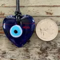 Detail showing 4cm heart-shaped blue evil eye glass pendant with braided cord - Heart Style