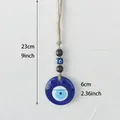 Handgefertigter Evil Eye Wandbehang mit 6cm blauem Glasanhänger und rustikalem Hanfseil - Blaues Auge / Kaffeeperlenstil
