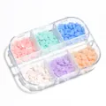 Detalle macro de adornos de uñas de corazón de resina en caja de 6 compartimentos - Corazón De 6 Segmentos Que Cambia De Color Con La Luz