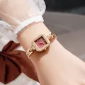 Elegant vintage square gold watch with burgundy dial and crystal accents on wrist - Gold Red