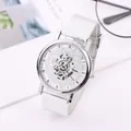 Skeleton quartz watch with silver mesh strap and Roman numerals on white desk - White