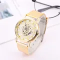 Macro view of golden hollow-out dial watch with mesh strap and roman numerals on a desk - Gold