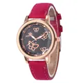 Détail d'une montre or rose avec cadran papillon étoilé et bracelet en suède fuchsia - Bordeaux