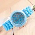 Detailansicht der Genfer hellblauen Silikonuhr mit roségoldener Lünette auf Holz - Hellblau