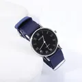 Gros plan de la montre quartz Geneva avec bracelet NATO bleu et chiffres romains argentés - Cadran Noir Bracelet Bleu