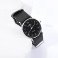 Détail d'une montre à quartz minimaliste avec chiffres romains et bracelet en nylon - Cadran Noir Bracelet Noir