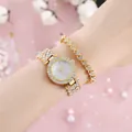 Dettaglio dell'orologio in strass dorati e braccialetto a cuore su sfondo rosa - Orologio Oro E Bracciale Cuore