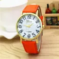 Detail of orange leather strap and gold case watch with marble dial and Arabic numerals - Orange