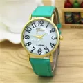 Minimalist quartz watch with green leather strap and gold case on light wood surface - Mint Green