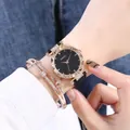 Primer plano de reloj oro rosa con esfera estrellada y pulsera con colgante de estrella - Reloj Y Pulseras / Negro