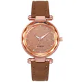 Detailed macro of a faceted glass watch face with rhinestone markers and quartz dial - Brown