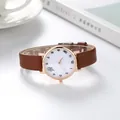 Minimalist women's watch with brown leather strap and cute cartoon dial on white desk - Brown