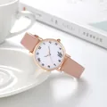 Détail du bracelet en cuir rose et boîtier doré rose avec icônes sur le cadran blanc - Rose