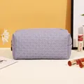 Lavender PU leather makeup bag with woven texture and gold zipper closure for travel - Woven Pattern / Purple