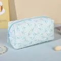 Blue floral cosmetic bag with textured fabric and top zipper closure for travel - Blue