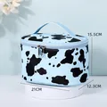 Blue and black cow print cosmetic bag with handle and size dimensions of 21x12.3x15.5cm - Oval Design