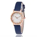 Women's blue leather strap watch with rose gold case and rhinestone bezel on white background - Blue