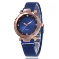 Détail du boîtier en or rose facetté et du bracelet à mailles bleues d'une montre - Bleu