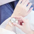 Macro shot of stylish white leather strap watch with cute cat dial and flower charm bracelet - Watch & Bracelet Set / White