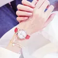 Close-up of cat-eared quartz watch with red leather strap and matching floral bracelet - Watch & Bracelet Set / Red