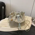 Light blue embroidered bucket bag with pearl handle and golden chain shoulder strap - Blue