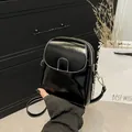 Glossy black leather crossbody phone bag with white stitching and dual zippers - Black