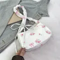 Floral canvas shoulder bag featuring pink rose prints and decorative bow straps - White
