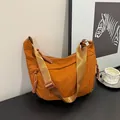 Burnt orange nylon crossbody crescent bag with thick woven zipper detail and strap - Brown
