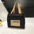 Sac fourre-tout minimaliste en toile noire avec anses brunes et étiquette vintage - Noir