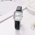 Macro shot of square silver dial with black leather strap on a minimal white background - Black