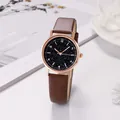 Detail of rose gold case with starry sky dial and brown leather strap on white surface - Brown