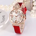 Gros plan sur une montre cœur en or rose avec cristaux, bracelet rouge et perles - Rouge