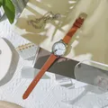 Dettaglio dell'orologio con orecchie di gatto e cinturino in pelle marrone naturale - Marrone