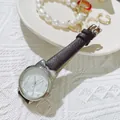 Detailed macro view of a cute cat ear watch with black leather strap on a white knit background - Black