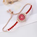 Detail of rhinestone bezel watch with red crystals and adjustable sliding gold buckle - Bracelet Watch / Red