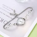 Détail macro de strass argentés en forme de feuille sur le bracelet réglable de cette montre - Argent