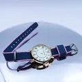 Close-up of a stylish NATO nylon strap watch on a reflective mirror surface - Army Green