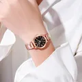Detail of rose gold quartz watch with black dial and metal chain strap on wrist - Black