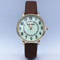 Detail view of quartz watch with Arabic numerals and brown canvas strap for women - Coffee